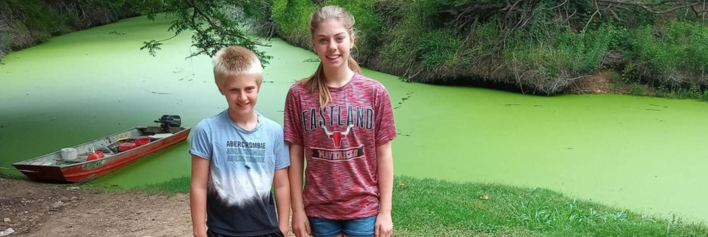 Aerial view of Inez Spring RV park on the Leon River with full‑hookup sites and kayaks on shore